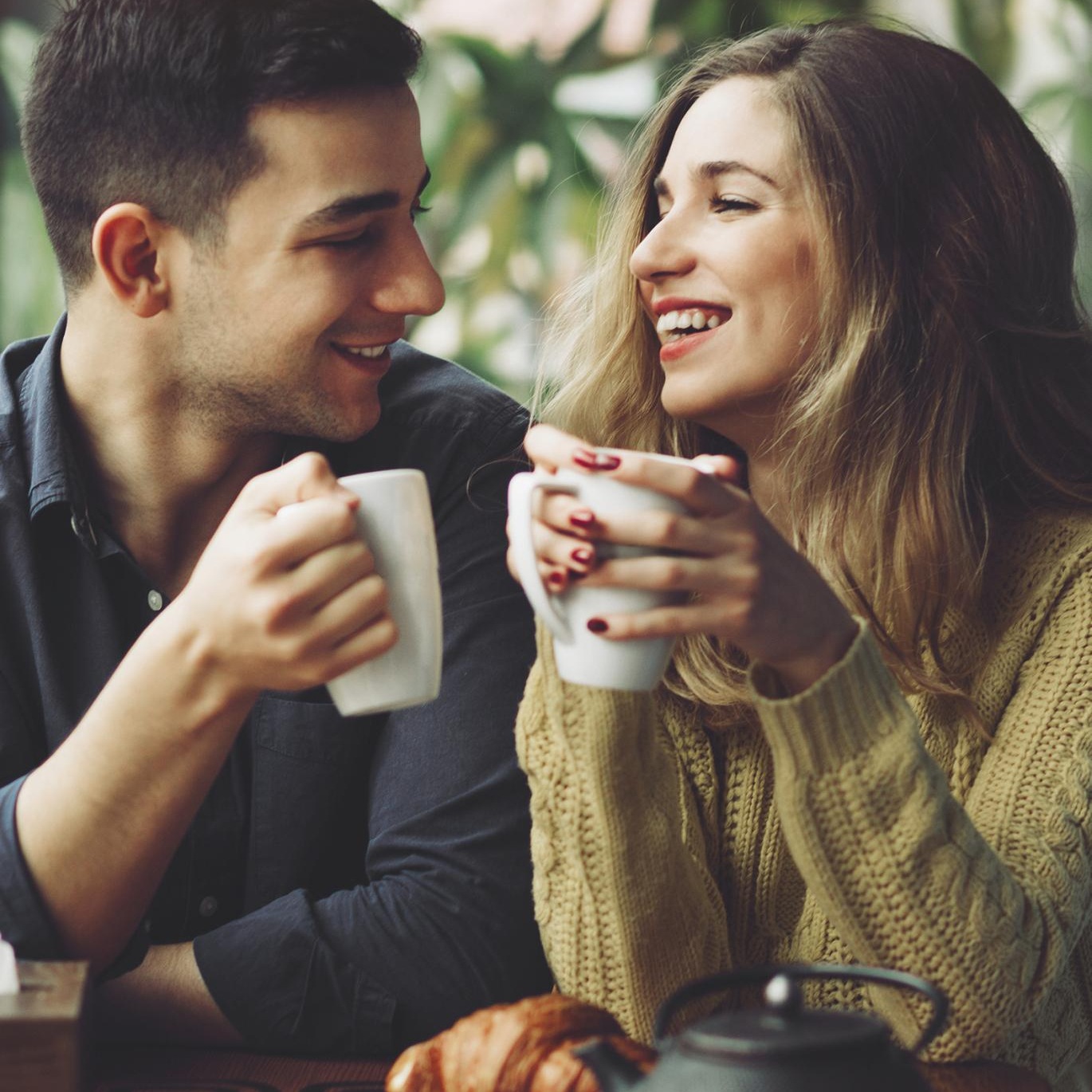 a man and woman sitting at a table and eating